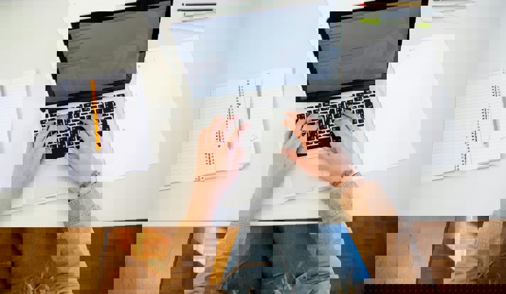 Woman Working On Laptop With Documents