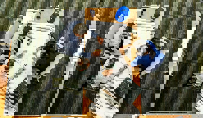 Three People Sitting Beside Table